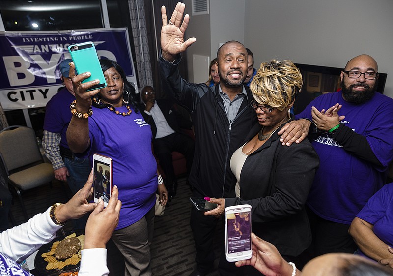 Anthony Byrd raises his hand while standing with campaign manager Veronica Dunson after receiving news of his victory over incumbent District 8 city councilman Moses Freeman at his election watch party at the Chattanoogan Hotel on Tuesday, March 7, 2017, in Chattanooga, Tenn.