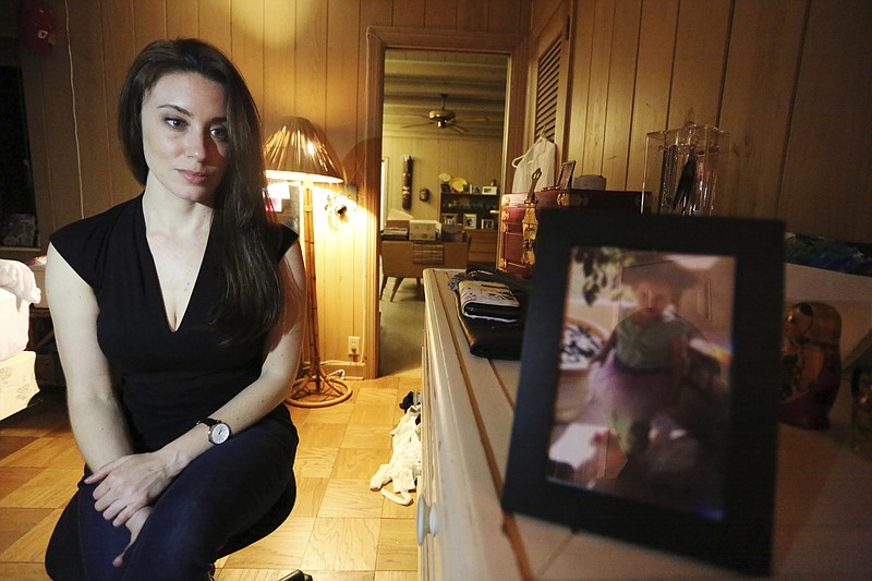 In this Feb. 13, 2017, photo, Casey Anthony poses for a portrait next to a photo of her daughter, Caylee, in her West Palm Beach, Fla., bedroom. In an exclusive interview with The Associated Press, Anthony claims the last time she saw Caylee she "believed that she was alive and that she was going to be OK." (AP Photo/Joshua Replogle)