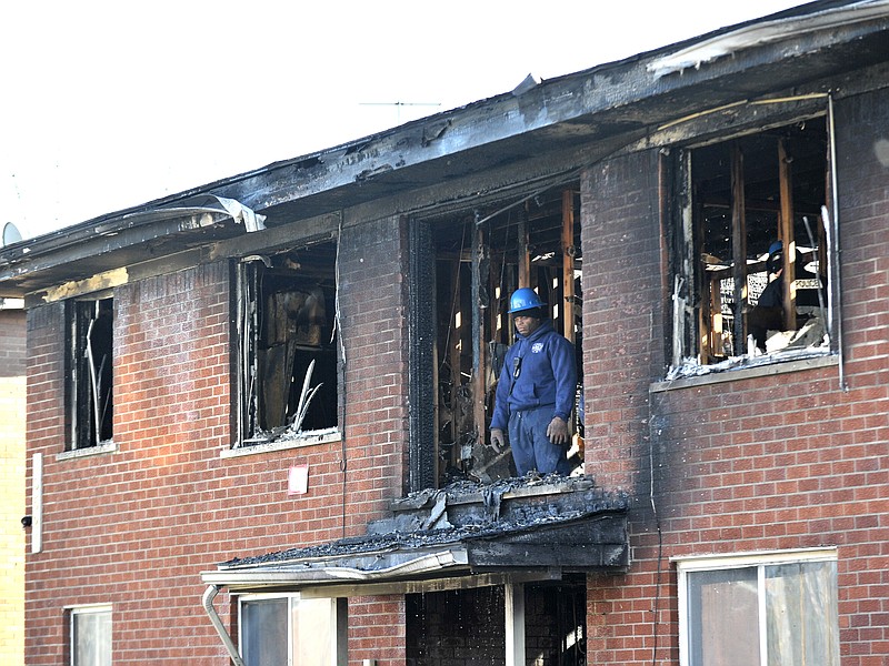 
              A Detroit Fire Department investigator stands on the second floor after a deadly fire at an apartment complex Wednesday, March 8, 2016, in Detroit. (Todd McInturf/Detroit News via AP)
            