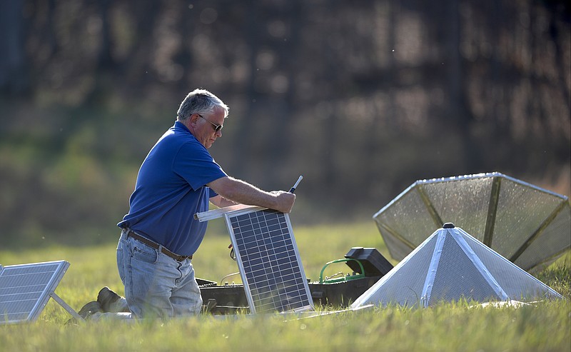 Eric Freimark sets up solar panels Thursday, March 8, 2017 that will be used to with tornado-monitoring equipment in Mountain Cove Farms.