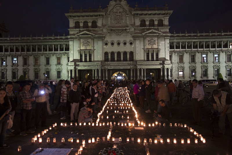 
              People hold a candlelight vigil outside the National Palace in remembrance of the girls who died in a fire at the Virgin of the Assumption Safe Home in Guatemala City, Thursday, March 9, 2017. A blaze, that killed at least 35 girls at a shelter for troubled youths, erupted when some of them set fire to mattresses to protest rapes and other mistreatment at the badly overcrowded institution, the parent of one victim said Thursday.  (AP Photo/Moises Castillo)
            