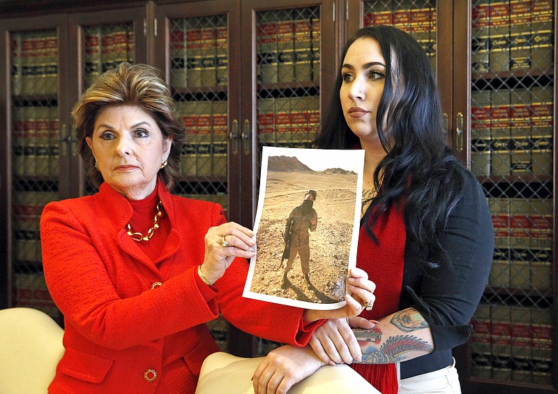 
              Former Marine Erika Butner, right, and attorney Gloria Allred hold photos of Butner in uniform, as she and another active-duty female Marine said photographs of them were secretly posted online without their consent, at a news conference in Los Angeles Wednesday, March 8, 2017. Nude photos of other servicewomen were also posted. Gen. Robert Neller, the Marine Corps commandant, has condemned the photo sharing and urged victims to report abuse. (AP Photo/Nick Ut)
            