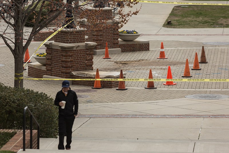 A UTC student walks Saturday near the scene of a fatal crash that occurred late Friday night at 700 Vine Street on the campus of UTC. The driver was killed after the vehicle traveled down several flights of stairs in a pedestrian area, and the passenger was transported with injuries.