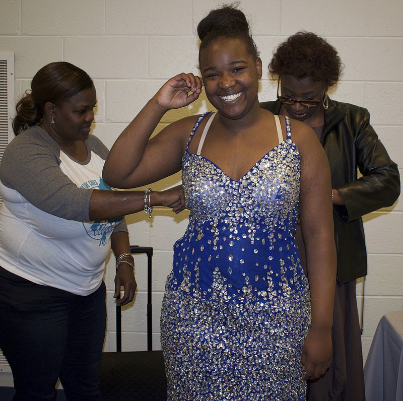 
              In this March 4, 2017, photo, volunteers make minor alterations to prom dresses selected by Nieyia Buckhanon and other girls at Colonial Middle School during the annual Her Prom Closet event in Memphis, Tenn. (Karanja A. Ajanaku/The New Tri-State Defender via AP)
            