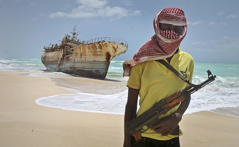 
              FILE - In this Sunday, Sept. 23, 2012 file photo, masked and armed Somali pirate Hassan stands near a Taiwanese fishing vessel washed ashore after the pirates were paid a ransom and the crew were released in the once-bustling pirate den of Hobyo, Somalia. Pirates have hijacked an oil tanker off the coast of Somalia, Somali officials and piracy experts said Tuesday, March 14, 2017, in the first hijacking of a large commercial vessel there since 2012. (AP Photo/Farah Abdi Warsameh, File)
            