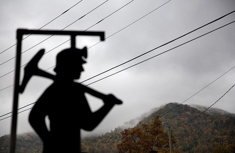 FILE - In this Oct. 16, 2014 file photo, fog hovers over a mountaintop as a cutout depicting a coal miner stands at a memorial to local miners killed on the job in Cumberland, Ky. The Republican-controlled Kentucky state legislature is on the cusp of lifting its decades-long moratorium on nuclear energy, a move unthinkable just three years ago in a state that has been culturally and economically dominated by coal. As the coal industry continues its slide, even Republican lawmakers are acknowledging a need for alternatives.  (AP Photo/David Goldman, File)