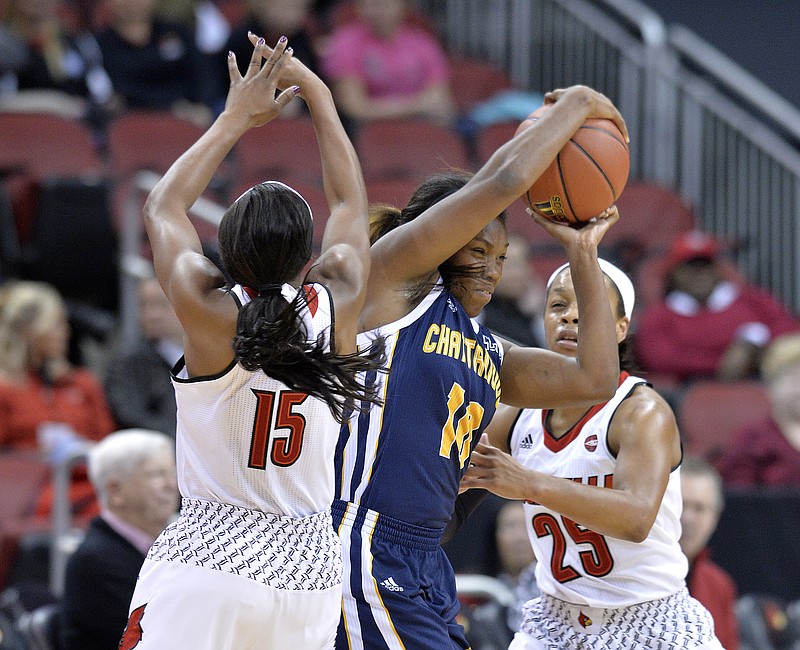Chattanooga's Queen Alford (10) fights through the defense of Louisville's Taylor Johnson (15) and Asia Darr (25) during the first half of an NCAA college basketball game, Monday, Nov. 21, 2016, in Louisville, Ky. (AP Photo/Timothy D. Easley)