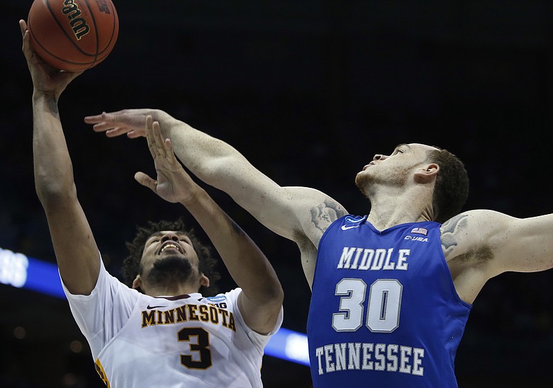 Minnesota's Jordan Murphy shoots over Middle Tennessee State's Reggie Upshaw during the second half of an NCAA college basketball tournament first round game Thursday, March 16, 2017, in Milwaukee. (AP Photo/Kiichiro Sato)