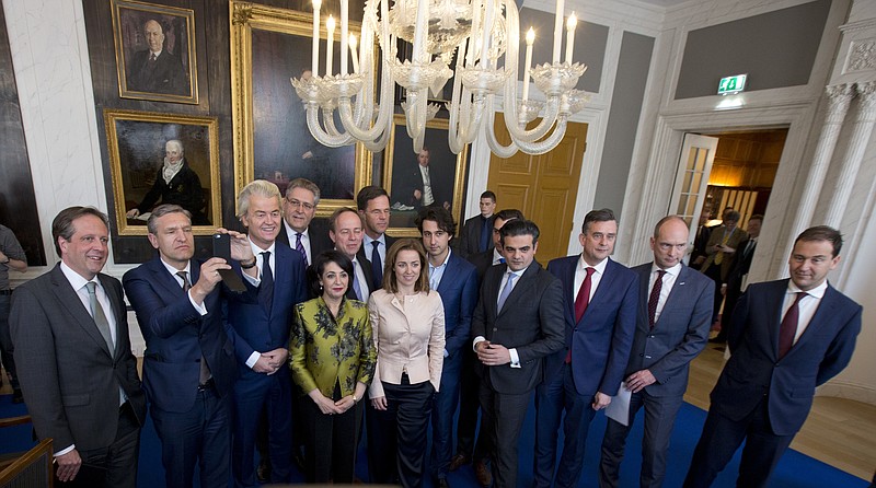 
              Political party leaders pose for a group picture with Khadija Arib, center left, the chairwoman of parliament, prior to discussing first steps in forming a new dutch coalition government in The Hague, Netherlands, Thursday, March 16, 2017. Dutch political parties were preparing Thursday to start what will likely be a long process of coalition talks after Prime Minister Mark Rutte's right-wing VVD easily won national elections, defying polls that suggested a close race with anti-Islam populist Geert Wilders. (AP Photo/Peter Dejong)
            