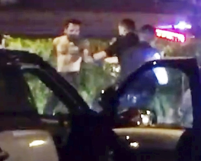 
              This March 12, 2017, image made from a video provided by Clay Connell shows a confrontation between Orange, Calif., police officers and a shirtless man during a traffic-stop-turned-standoff. A video obtained Thursday, March 16, by The Associated Press shows Michael Perez exit the driver’s side window of a minivan after police broke windows and used the hose to end a standoff late Sunday. Police scream "knife" seconds before the Perez is fatally shot. (Clay Connell via AP)
            