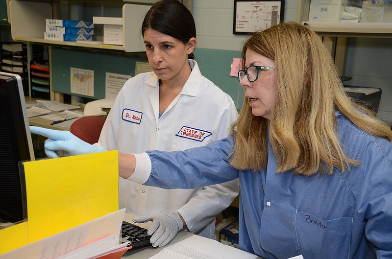 From left, Dr. Robyn Haines; Head, Pathology Section; Kord Animal Health Diagnostic Laboratory and Bonita Phillippie; Head, Serology  Section; Kord Animal Health Diagnostic Laboratory work on the laboratory analysis of Avian Influenza samples. - 