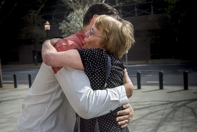 Marianne Quinn the mother of Aaron Quinn, one of Matthew Muller's victims, hugs one of her son's friends Thursday, March 16, 2017, in Sacramento, Calif. Muller, a disbarred Harvard University-trained attorney, was sentenced to 40 years in prison Thursday after emotional testimony from his victims in a kidnapping so elaborate and bizarre that police in California initially dismissed it as a hoax. (Hector Amezcua/The Sacramento Bee via AP)

