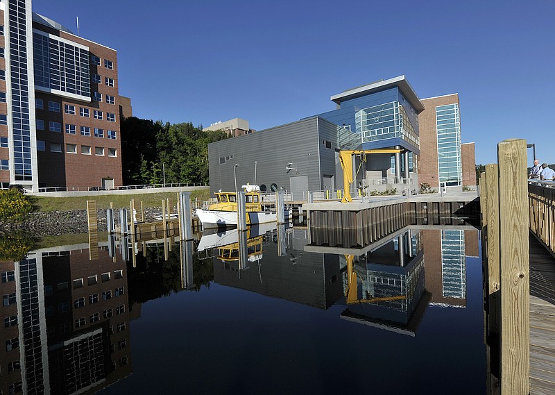 
              FILE - In this July 24, 2012, file photo, the Great Lakes Research Center is reflected in the waters of the docking area with RV Agassiz ready to go at Michigan Tech University in Houghton, Mich. The closure of a regional airport could force residents of Houghton in upper Michigan to drive eight hours to catch a flight. President Donald Trump’s budget proposes deep spending cuts to scores of domestic programs that, in some cases, risk backlash from the voters that helped propel him to the White House. (Dale G. Young/Detroit News via AP)
            