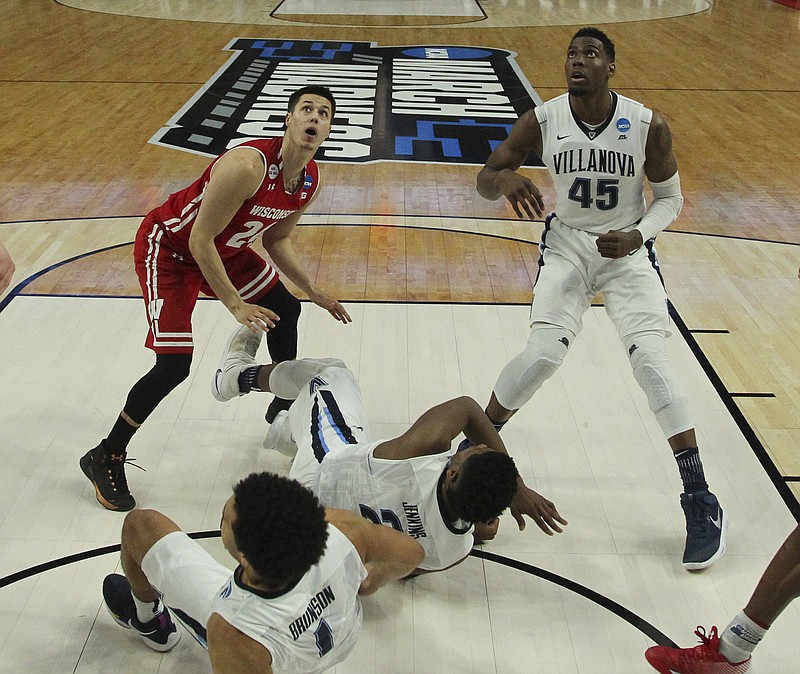 
              Wisconsin guard Bronson Koenig (24) watches as his shot is defended against by Villanova forward Darryl Reynolds (45), guard Jalen Brunson (1) and forward Kris Jenkins (2) during the second half of a second-round men's college basketball game in the NCAA Tournament, Saturday, March 18, 2017, in Buffalo, N.Y. (AP Photo/Bill Wippert)
            