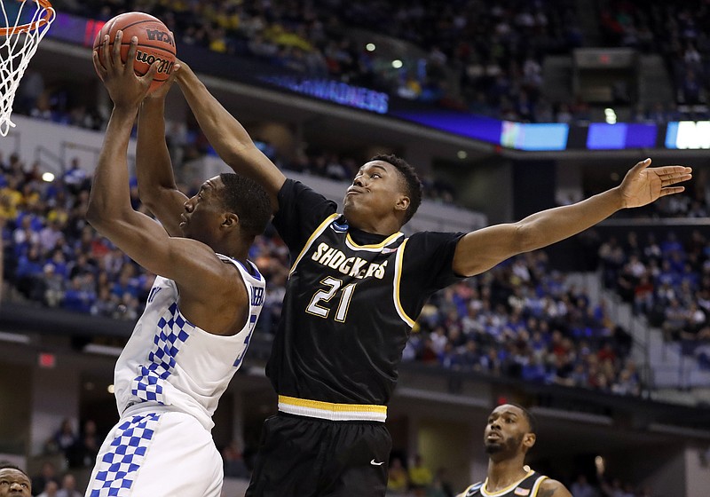 
              Kentucky's Bam Adebayo, left, heads to the basket as Wichita State's Darral Willis Jr. (21) defends during the first half of a second-round game in the men's NCAA college basketball tournament Sunday, March 19, 2017, in Indianapolis. (AP Photo/Jeff Roberson)
            