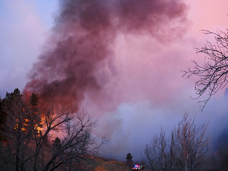 
              Smoke rises from a wildfire Sunday, March 19, 2017, in Boulder, Colo. Authorities said the small wildfire burning in the mountains forced people from their homes and is filling the sky with smoke. (Seth Frankel via AP)
            