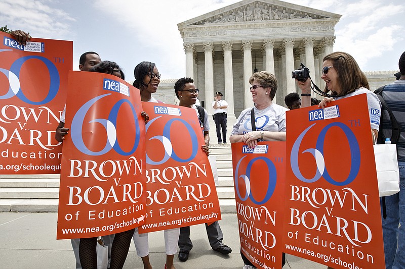 
              FILE - In this May 13, 2014, file photo National Education Association staff members from Washington joining students, parents and educators at a rally at the Supreme Court in Washington on the 60th anniversary Brown v. Board of Education decision that struck down "separate but equal" laws that kept schools segregated. From the time Americans roll out of bed in the morning until they turn in, and even who they might be spending the night with, the court's rulings are woven into daily life in ways large and small. (AP Photo)
            