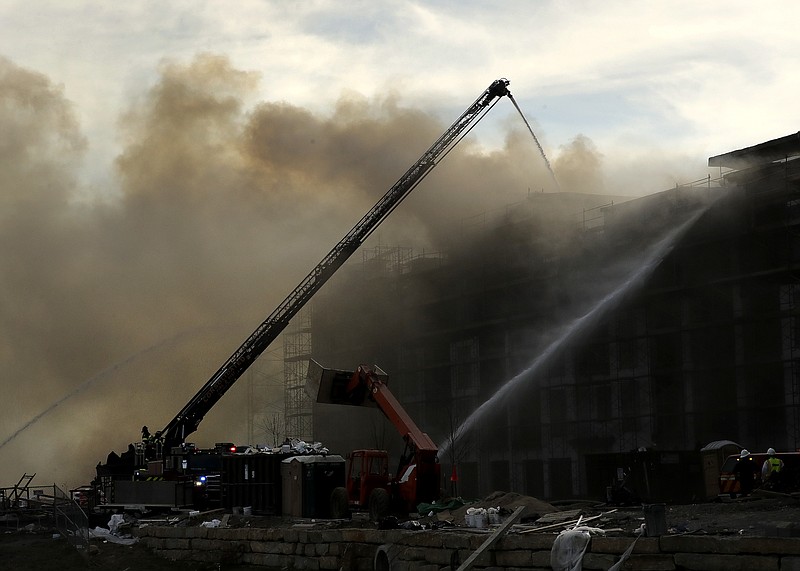 
              Firefighters fight an eight-alarm fire that began at an apartment complex under construction and than spread to several nearby homes Monday, March 20, 2017, in Overland Park, Kan. (AP Photo/Charlie Riedel)
            