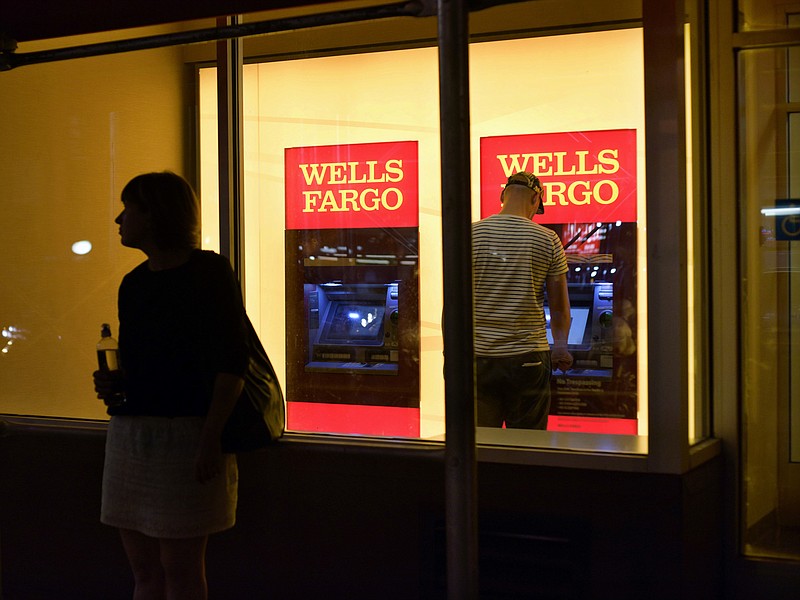 
              FILE - In this Sept. 21, 2016, file photo, a customer uses a Wells Fargo bank ATM in New York. On Tuesday, March 21, 2017, Wells Fargo announced plans to upgrade all 13,000 of its ATMs to allow customers to access their funds using their cellphones instead of traditional bank cards. (AP Photo/Patrick Sison, File)
            
