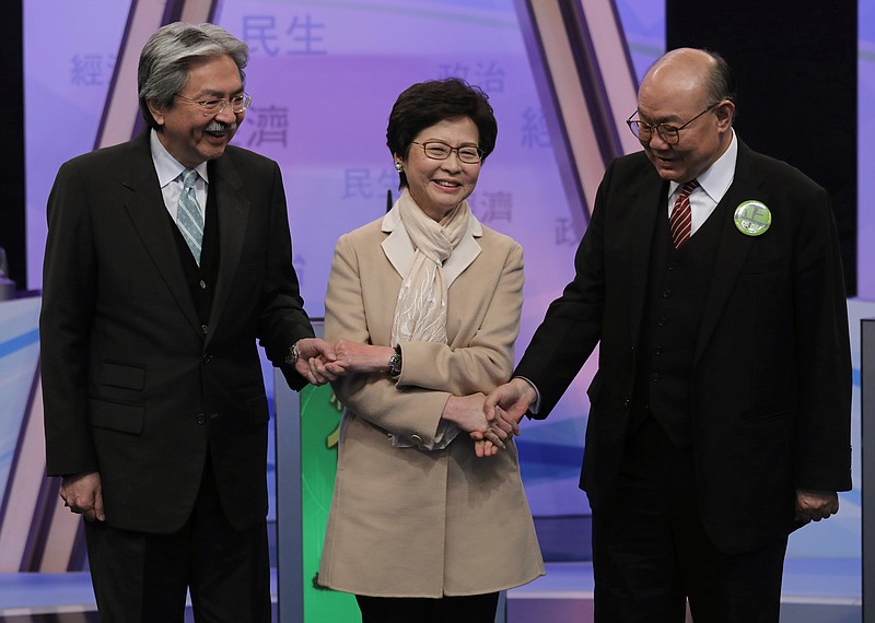 
              FILE - In this Tuesday, March 14, 2017 file photo, Hong Kong chief executive candidates, from left, former financial secretary John Tsang, former chief secretary Carrie Lam, and former judge Woo Kwok-hing, hold hands together during a photo call before a chief executive election debate in Hong Kong. Hong Kong is poised to select a new leader on March 26, but the choice will be made by a committee of mostly pro-Beijing elites rather than voters from among the city’s 7.3 million residents, under a system that was strongly criticized during 2014’s huge pro-democracy protests. (AP Photo/Vincent Yu, File)
            