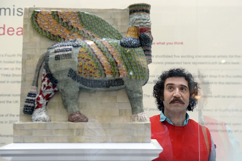 
              Michael Rakowitz looks at his design, The Invisible Enemy Should Not Exist, one of two commissions for Trafalgar Square's Fourth Plinth, at the National Gallery in central London, Tuesday, March 21, 2017. The next two artworks to be showcased on the Fourth Plinth in London’s famous Trafalgar Square have been selected. The art platform is currently home to a giant bronze thumb but will be replaced in 2018 by a re-creation of an ancient sculpture destroyed by the Islamic State group, it was announced Tuesday (Victoria Jones/PA via AP)
            