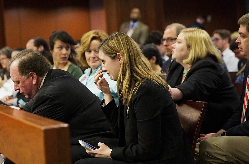 
              Grace Starling, center, a law student at Georgia State University, activist and sexual assault victim, wipes away tears after her father Kenneth Starling, left, testified before a Georgia Senate subcommittee on a bill overhauling colleges' disciplinary hearings on sexual violence in Atlanta, Tuesday, March 21, 2017. The subcommittee heard more than an hour of testimony Tuesday on the bill but didn't vote. Opponents say it will discourage victims from coming forward. The bill's sponsor, Georgia Rep. Earl Ehrhart, R-Powder Springs, says it will protect the rights of accused students. (AP Photo/David Goldman)
            