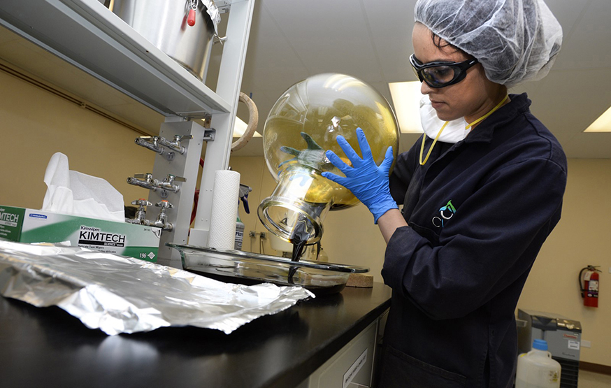 A worker pours out hemp oil after removal of isopropyl alcohol in a hot water bath at the CWHemp facilities in Boulder, Colo.