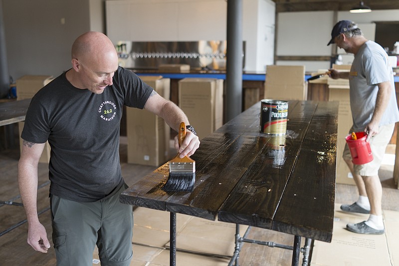 Staff Photo by Dan Henry / The Chattanooga Times Free Press- 3/22/17. Chris Calhoun, owner/operator of the Tap House in St. Elmo, works on finishing some hand built tables in the new bar which he hopes to be ready to open on the first of April. 
