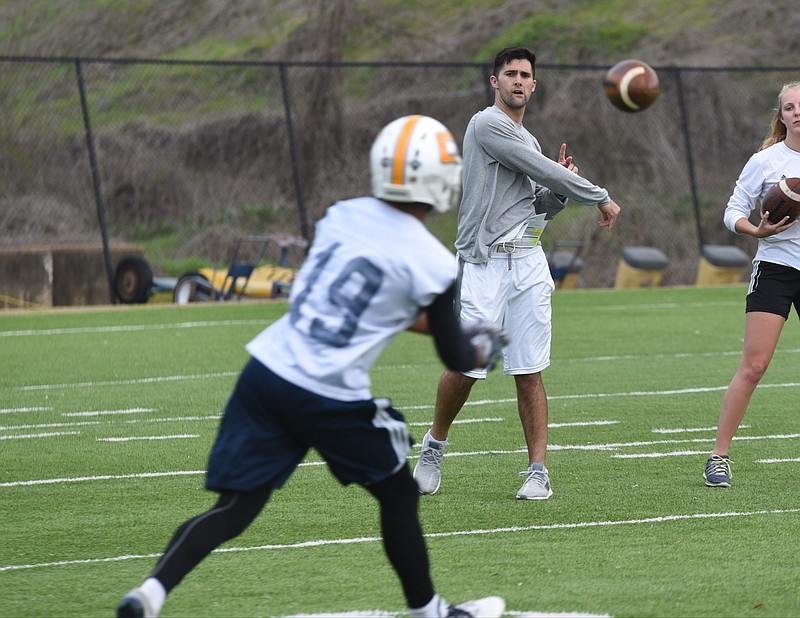 New UTC wide receivers coach Ryan Aplin throws to Brandon Jordan at Scrappy Moore Field on Tuesday, the first day of spring practice. Aplin's experience as a quarterback helps him show his receivers a different side of the offense.