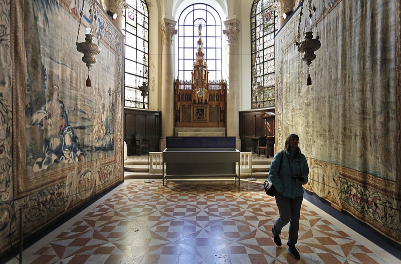 
              A woman walks through an exhibit of tapestries at the Cathedral of St. John the Divine in New York, Wednesday, March 22, 2017. Experts at the cathedral just spent 16 years sprucing up its super-size wall hangings with a labor-intensive process that uses dental probes, tweezers and other tools. Now the historic house of worship is inviting the public to enjoy the fruits of its labors. An exhibit called "The Barberini Tapestries, Scenes from the Life of Christ" runs through June 25. (AP Photo/Seth Wenig)
            