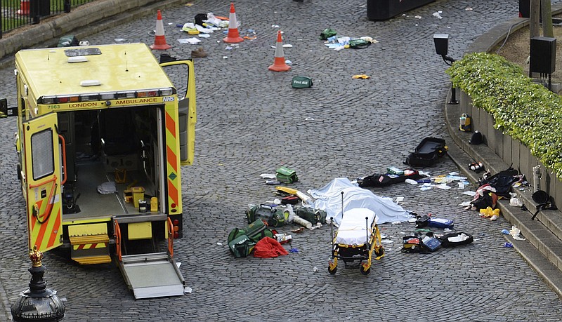 
              A body is covered by a sheet outside the Houses of Parliament, London, Wednesday, March 22, 2017.  London police say they are treating a gun and knife incident at Britain's Parliament "as a terrorist incident until we know otherwise." The Metropolitan Police says in a statement that the incident is ongoing. It is urging people to stay away from the area. Officials say a man with a knife attacked a police officer at Parliament and was shot by officers. Nearby, witnesses say a vehicle struck several people on the Westminster Bridge.  (Stefan Rousseau/PA via AP).
            