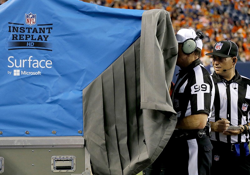 
              FILE - In this Aug. 7, 2014, file photo, referee Tony Corrente (99) watches an instant replay during the second half of an NFL preseason football game in Denver. The NFL is making plans to speed up the pace of games, including changing how video replays are handled and using a time clock for extra points. (AP Photo/Jack Dempsey, File)
            