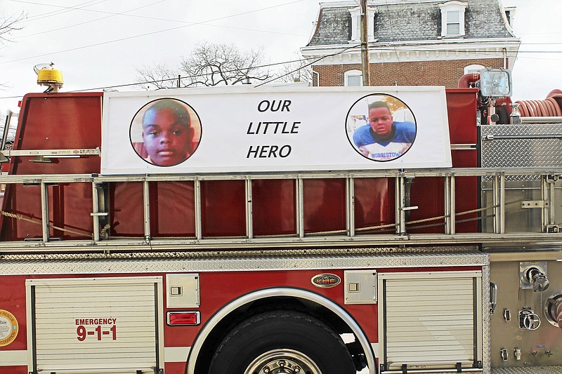 
              In this Feb. 13, 2016 photo, a fire truck with a banner displaying photos of Sanford Harling III sits outside Christian Network Outreach United Church of Christ before funeral services for Harling in Norristown, Pa.  Harling III,  who died trying to save his father from a house fire is among 20 people being honored with Carnegie medals for heroism.  The Carnegie Hero Fund Commission is named for the late steel magnate and philanthropist Andrew Carnegie, who was inspired by stories of heroism during a coal mine disaster that killed 181 people, including a miner and an engineer, who died trying to rescue others. The Carnegie Hero Fund Commission, based in Pittsburgh, announced the winners Wednesday, March 22, 2017.  (Oscar Gamble/The Times Herald via AP)
            
