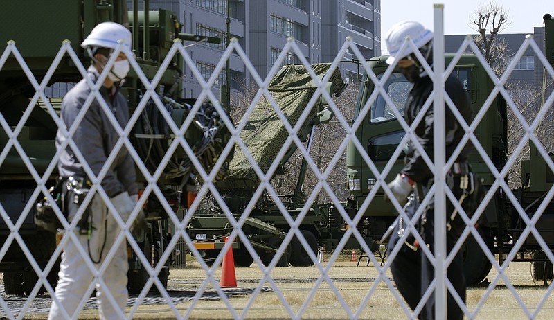 Workers set up a fence around the PAC-3 Patriot missile unit deployed against North Korea's missile firing at the Defense Ministry in Tokyo, Wednesday, March 22, 2017. North Korea's latest missile launch Wednesday appears to have ended in a failure. That's what South Korean defense officials say, three days after the North claimed a major breakthrough in its rocket development program. (AP Photo/Shizuo Kambayashi)
