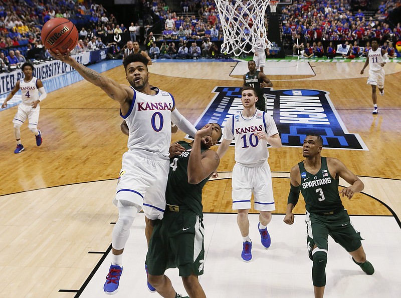 
              Kansas guard Frank Mason III (0) shoots in front of Michigan State forward Nick Ward (44) and guard Alvin Ellis III (3) during the first half of a second-round game in the NCAA men's college basketball tournament in Tulsa, Okla., Sunday, March 19, 2017. (AP Photo/Sue Ogrocki)
            