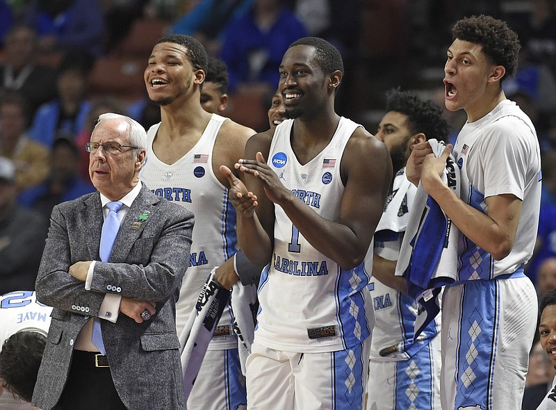 
              FILE- In this March 17, 2017, file photo, North Carolina head coach Roy Williams, left, and players Kennedy Meeks, Theo Pinson and Justin Jackson react during the second half against Texas Southern in a first-round game of the NCAA men's college basketball tournament in Greenville, S.C. Williams has long emphasized the importance of rebounding and his Tar Heels lead the country in rebounding margin entering the Friday, March 24, game against Butler in the NCAA Tournament's South Region semifinals. (AP Photo/Rainier Ehrhardt, File)
            