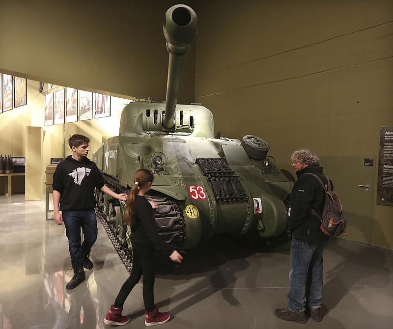 
              FILE -In this file photo taken in Gdansk, Poland, Jan. 23, 2017, visitors look at an exhibit in the Museum of the Second World War, an ambitious new museum under creation for nine years, that opened its doors for one day to historians and reporters. It opened to visitors on Thursday, March 23, 2017, amid plans by the conservative government to change its content to fit its nationalist views. (AP Photo/Czarek Sokolowski, File)
            