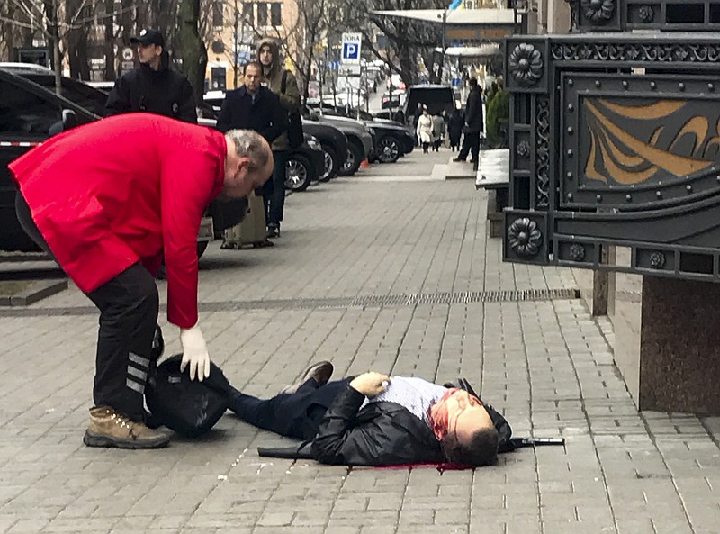 
              EDS NOTE: GRAPHIC CONTENT A hotel employee tries to help Denis Voronenkov minutes after he was shot in Kiev, Ukraine, Thursday, March 23, 2017.  Ukrainian police said Voronenkov was shot dead Thursday by an unidentified gunman at the entrance of an upscale hotel in the Ukrainian capital. Voronenkov, 45, a former member of the communist faction in the lower house of Russian parliament, had moved to Ukraine last fall and had been granted Ukrainian citizenship. (AP Photo/Alisa Berezutsskaya)
            