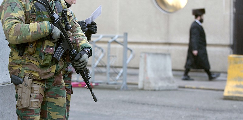 
              FILE - In this Jan. 17, 2015 file photo, Belgian para-commandos patrol near a synagogue in the center of Antwerp, Belgium. Belgian authorities on Thursday, March said they have raised security in the port of Antwerp after a car with French license plates drove at high speed through a busy shopping street, forcing pedestrians to jump out of the way. (AP Photo/Virginia Mayo)
            