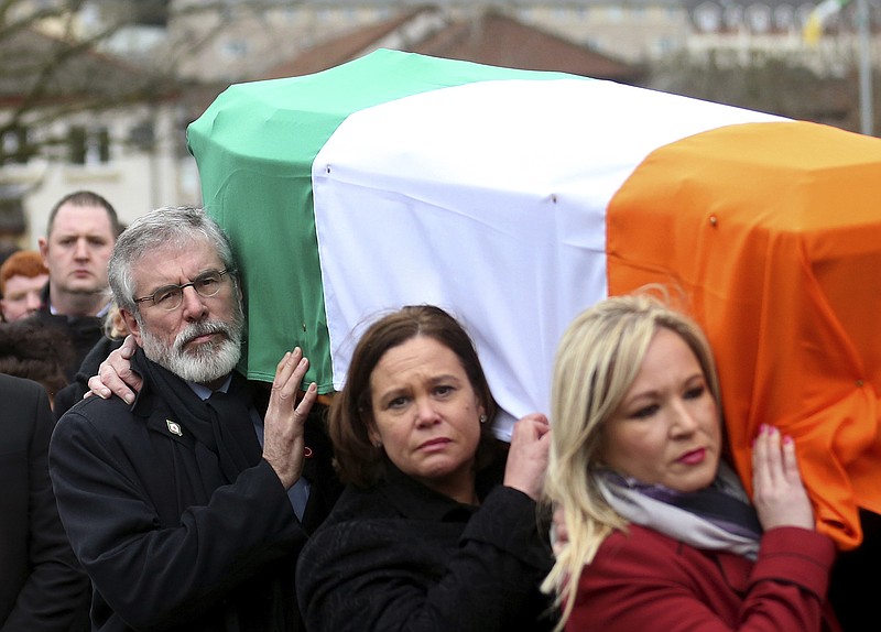 
              Sinn Fein's Gerry Adams, left, Mary Lou McDonald, centre, and Michelle O'Neill carry the coffin of former IRA commander and Sinn Fein deputy leader Martin McGuinness to St Columba's Church in Londonderry, Northern Ireland, Thursday, March 23, 2017. McGuinness helped lead his militant movement to compromise with British Protestants. (AP Photo/Peter Morrison)
            