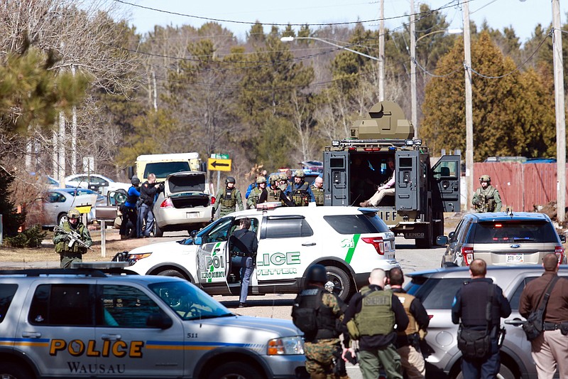 
              Numerous law enforcement vehicles and SWAT teams respond to shooter Wednesday, March 22, 2017, at an apartment complex in Rothschild, Wis. The shootings happened at a bank, a law firm and an apartment complex, where officers, including a SWAT team, were in a standoff with the suspect late in the afternoon, Wausau police Capt. Todd Baeten said at a news conference. The area is about 90 miles west of Green Bay.  (T'xer Zhon Kha /The Post-Crescent via AP)
            