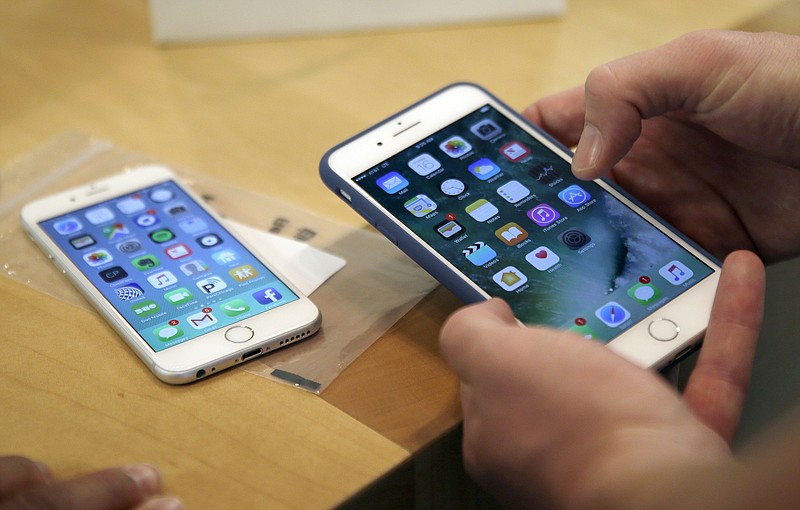 
              FILE - In this Friday, Sept. 16, 2016, file photo, a customer sets up his new iPhone 7 Plus, right, as he switches from the iPhone 6 at the Apple Store on Michigan Avenue during the release of the Apple iPhone 7 and the latest Apple Watches, in Chicago. New documents from WikiLeaks, posted Thursday, March 23, 2017, point to an apparent CIA program to hack Apple’s iPhones and Mac computers such that the exploits persist even after the devices are reset to factory conditions. Security experts say the exploits are plausible, but they are playing down the threat to typical users. The techniques typically require physical access to devices, something the CIA would only use for individuals it is targeting. (AP Photo/Kiichiro Sato, File)
            