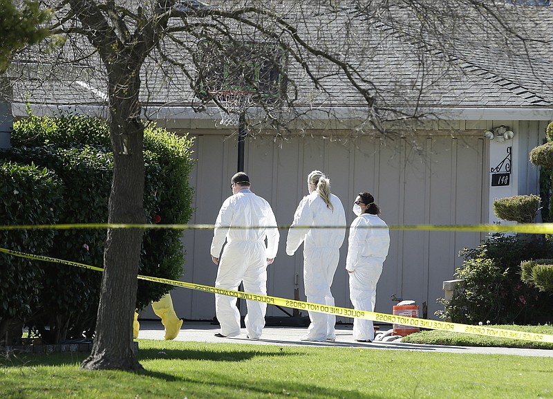 
              Investigators walk to the home where four people were found dead, Thursday, March 23, 2017, in Sacramento, Calif. A suspect is being held in San Francisco. Police are not saying how the four were killed and are not immediately identifying the victims, including their genders and ages. (AP Photo/Rich Pedroncelli)
            