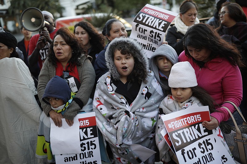 
              FILE – In this Nov. 29, 2016, file photo, people protest as part of the National Day of Action to Fight for $15 near a McDonald's restaurant along the Las Vegas Strip in Las Vegas. A cluster of Black Lives Matter groups and the organization leading the push for a $15-an-hour wage are joining forces to combine the struggle for racial justice with the fight for economic equality, just as the Rev. Martin Luther King Jr. tried to do in the last year of his life. They are launching their first national joint action on April 4, 2017, the 49th anniversary of King’s assassination, with “Fight Racism, Raise Pay” protests in two dozen cities, including Atlanta; Chicago; Boston; Denver; and Las Vegas. (AP Photo/John Locher, File)
            