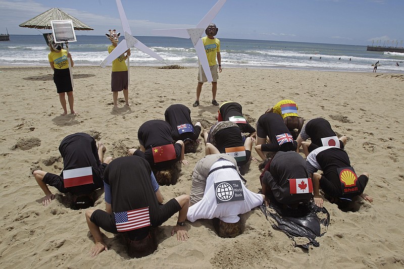 Protestors bury their heads in the sand in an attempt to depict countries with a lack of concern over climate change at a 2011 summit in Durban, South Africa.