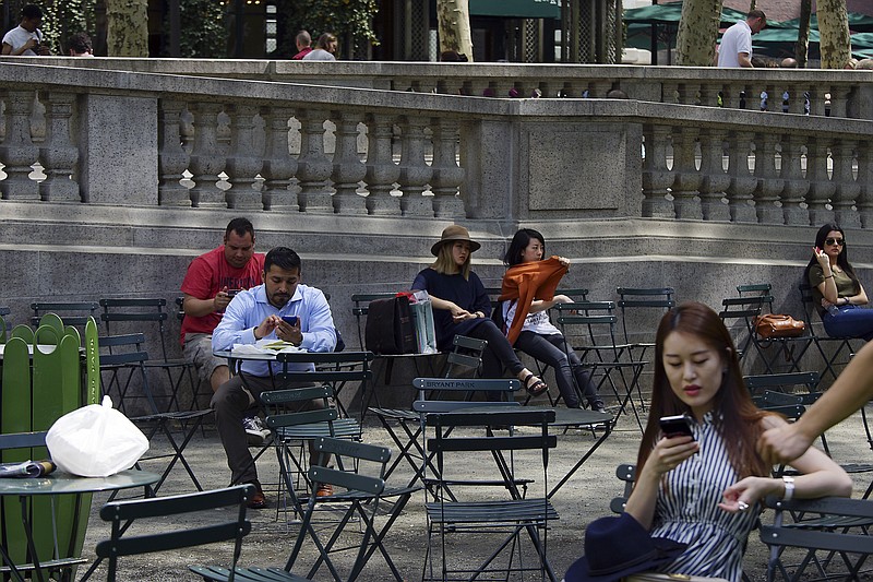 FILE — Visitors on their phones in Bryant Park in Manhattan in 2015. The Senate voted this week to overturn rules that required telecom companies to ask permission before tracking users' behavior, beginning a repeal of Obama-era regulations. (Todd Heisler/The New York Times)