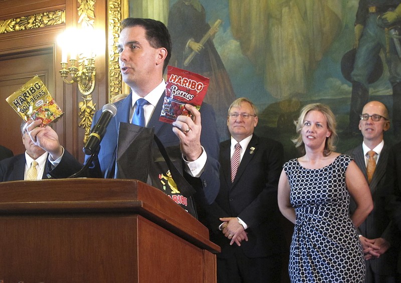 
              Wisconsin Gov. Scott Walker holds up two bags of Haribo candy when announcing the German-based company would be building its first North American manufacturing plant in southeast Wisconsin not far from Chicago on Thursday, March 23, 2017, in Madison, Wis. (AP Photo/Scott Bauer)
            