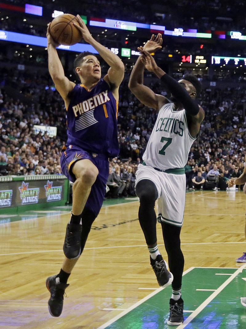 Phoenix Suns guard Devin Booker (1) goes up for a shot against Boston Celtics forward Jaylen Brown (7) during the first quarter of an NBA basketball game, Friday, March 24, 2017, in Boston. Booker scored 70 points, but the Celtics won 130-120. (AP Photo/Elise Amendola)

