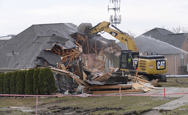 
              A house in Fraser, Mich. is demolished  to help clear the way for repairs to a broken sewer line that caused a sinkhole on Christmas Eve in suburban Detroit, on Friday, March 24, 2017.  Three houses had to be condemned in Fraser and a major road has been closed. Macomb County Public Works spokesman Dan Heaton says one of those homes was demolished on Friday and the other is expected to be torn down on Monday.  (Clarence Tabb Jr./Detroit News via AP)
            