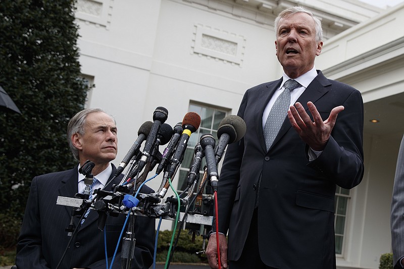 
              Texas Gov. Greg Abbott listens at left, as Charter Communications CEO Thomas Rutledge speaks to reporters outside the White House in Washington, Friday, March 24, 2017, after meeting with President Donald Trump. (AP Photo/Evan Vucci)
            